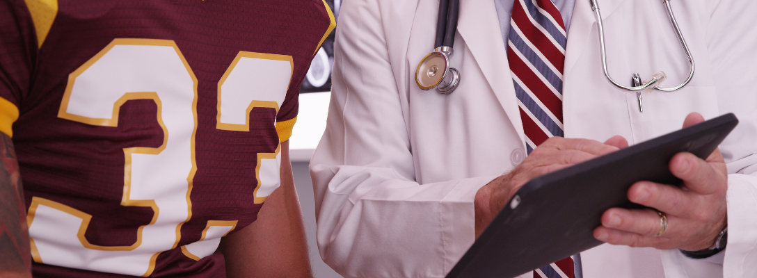 Doctor Discussing Sports Injury Report with Football Player